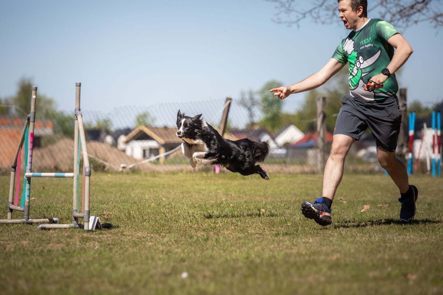 Przewodnik biegnący z psem na treningu agility